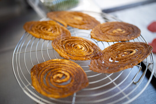 Freshly Baked Spiral French Arlette Biscuits Puff Pastry Dough on Wire Cooling Rack Ready for Garnish