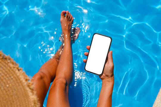 phone in hand by the pool.