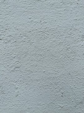 Rough white painted wall texture with subtle crack and bumpy plaster surface