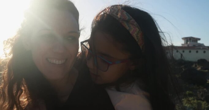 Happy mother having tender moment with little daughter outdoor during sunset time - Family lifestyle, bonding and love concept - UGC content