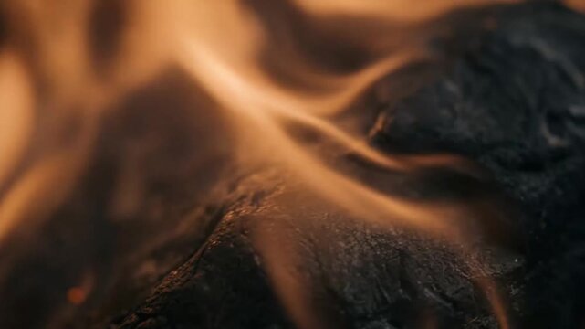 Close-up of burning coal with flickering orange flames showcasing intense heat and fiery glow