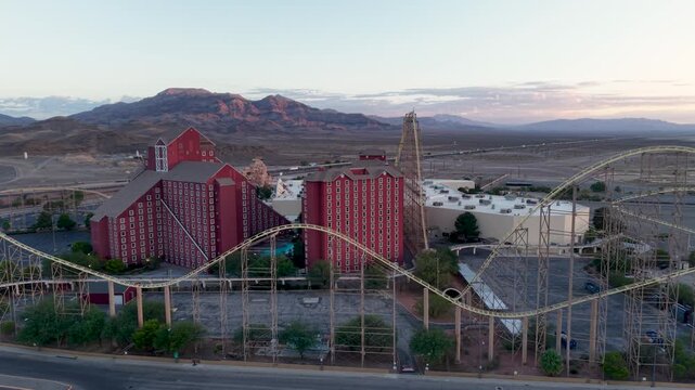 Aerial orbit of the Abandoned Hotel Casino and Roller Coaster attraction at the Ca-Nevada state line. The drone exposes the sheer size of this once popular Ride and the vast Nevada desert beyond