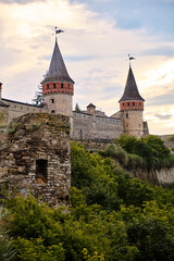 Kamianets-Podilskyi, Ukraine, june 23, 2026 A beautiful scenic shot of the prominent stone towers of the Kamianets-Podilskyi castle fortress under a soft, golden sunset sky. © Olena