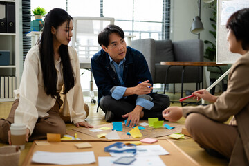 Fototapeta premium Group of young asian creative business brain storm meeting presentation,discussing roadmap to product launch, planning,strategy,new business development,working with new startup project in office.