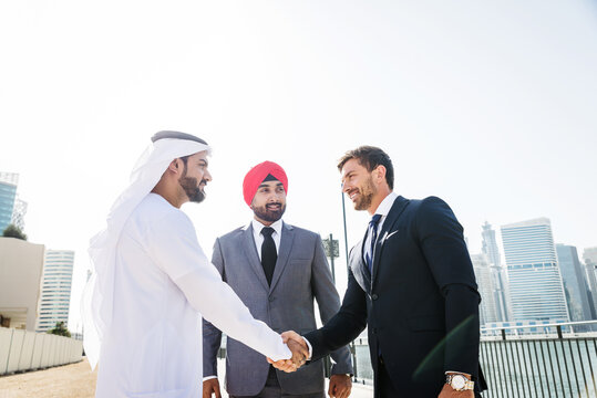 Group of muticultural corporate businessmen meeting outdoors in Dubai for a business deal