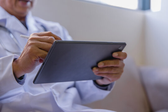 Doctor using digital tablet to review patient information and medical records in a modern clinic. Healthcare technology