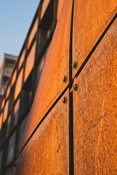 Rusty metal panels with bolts on industrial building facade