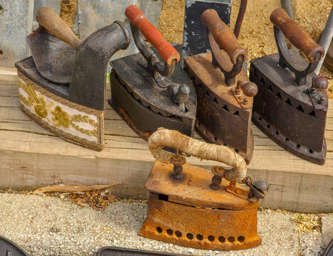 Vintage cast iron clothes irons on display at flea market for buyers and collectors