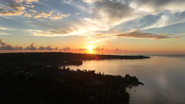 Morning sun rising above the forested coast of Lemon Island