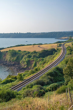 Beautiful Devon coastline with a train track winding across the frame. South Devon and Torbay tourism. Part of the English Riviera. Torquay, Paignton, Brixham. Dartmouth steam railway. 
