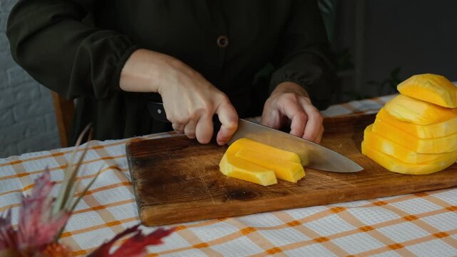 Female hands slicing pumpkin. Preparing autumn food. Cooking pumpkin soup or cake.