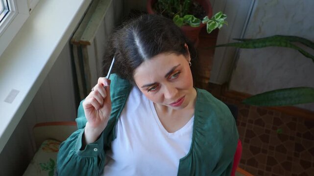 Top view of a thoughtful young Caucasian woman touching her head with a pencil while thinking. Problem solving, creative ideas, concentration, education, and decision making concept