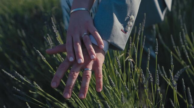 Close Up of Wedding Rings on Couple Hands in Lavender Field