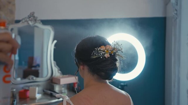Hairdresser Applying Hairspray to Bride Floral Wedding Hairstyle