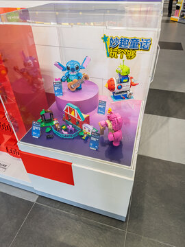 LEGO Disney toy display featuring assembled Stitch with ukulele, Lotso bear, and Alien rocket sets inside a transparent showcase in store. Editorial use only. Shanghai, China, 05-25-2026