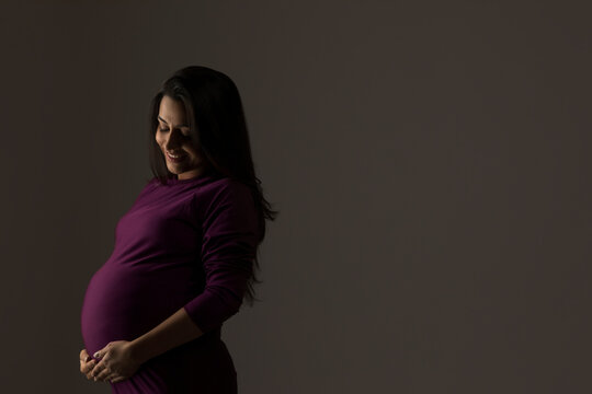 Pregnant woman thinking about her baby and smiling.