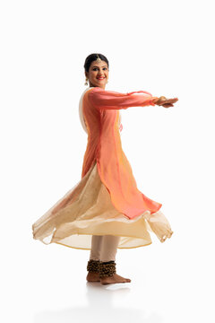Beautiful kathak dancer performing in front of a white background. 