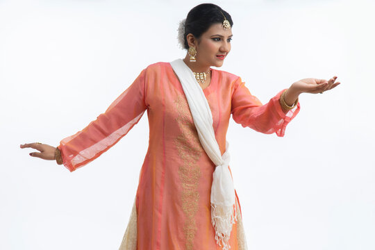 Beautiful kathak dancer performing in front of a white background. 