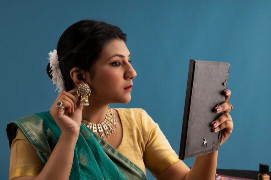 Kathak dancer checking her earrings in the mirror. 