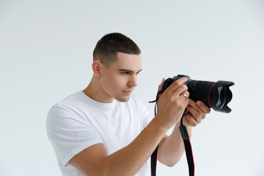 Happy handsome photographer man posing holding photo camera isolated on white background