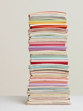Large stack of colorful magazines and books on light background
