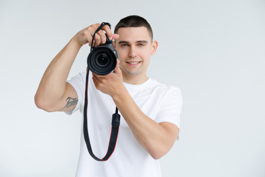 Young man with digital camera on white background