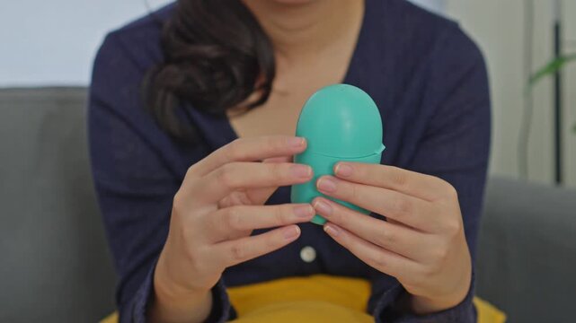 Close-up of female hands storing green period cup inside protective sterilization container