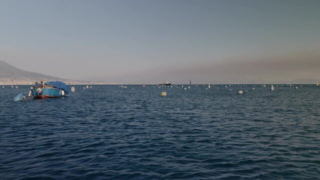A boat harvesting mussels from a farm in the Gulf of Naples along the Mediterranean coast.