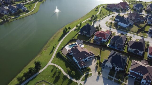 Scenic lakeside properties overlook manicured community walking paths decorative water fountains in Frisco, TX. Suburban residential blocks extend outward toward greater Dallas Fort Worth