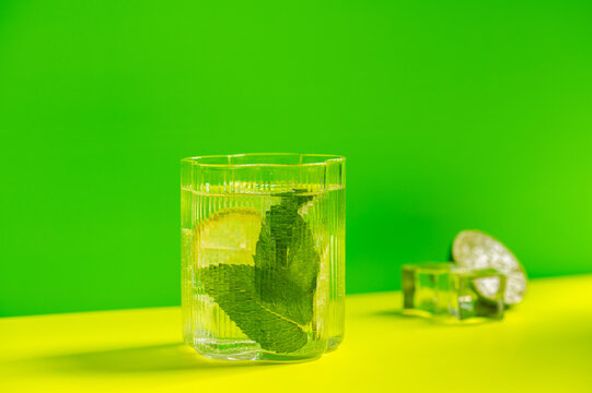 Mojito cocktail with lime and mint on bright background