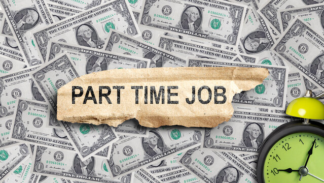 A torn piece of cardboard with the text Part Time Job, placed over a background of US dollar bills with a green alarm clock, symbolizing time management, income, and employment. Concept of Flextime