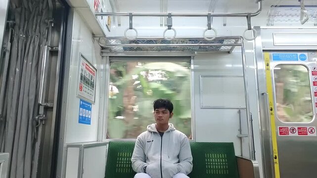 Passenger Sitting Inside Commuter Train During Daytime Travel 