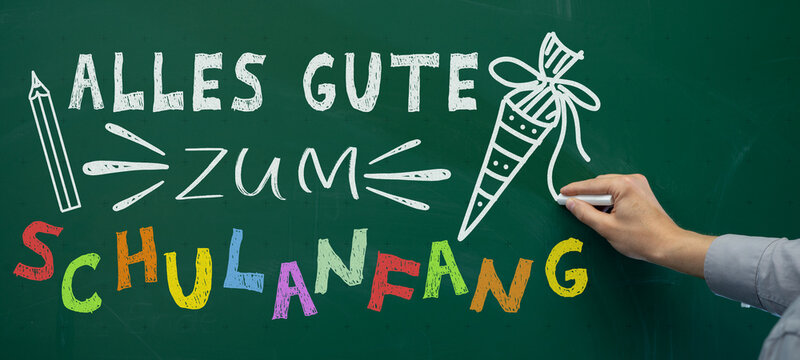 Schule, Einschulung, Schulstart, Schulbeginn, Konzept Gru&szlig;karte - Alles Gute zum Schulanfang - Hand von Lehrer der deutschen Text mit Kreide auf gr&uuml;ne Schultafel Kreidetafel schreibt