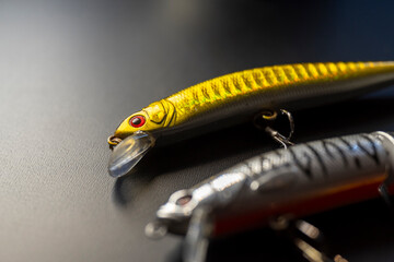 Silver minnow fishing lure on black surface The Concept of predator angling gear © VicVaz
