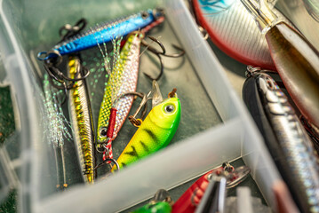 Fishing lures in plastic tackle box compartment The Concept of sport fishing gear and organization © VicVaz