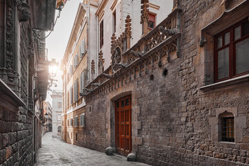 Obraz premium Barcelona, Spain. Barri Gotic Quarter. Antique stone walls with sculptures of medieval buildings in in old town. Famous touristic landmark and travel destination. Sunset evening street perspective.