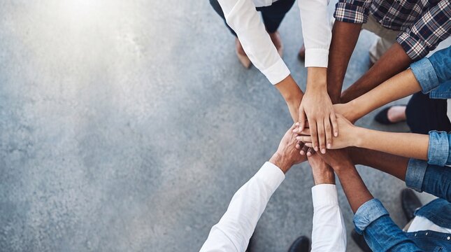 Diverse business team stacking hands together in unity for corporate collaboration success high angle