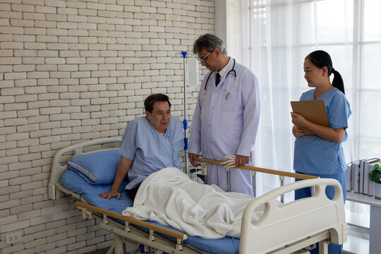Senior doctor and nurse visiting an elderly patient recovering in a hospital bed. Healthcare professionals providing medical consultation, patient care, and rehabilitation support in a hospital room
