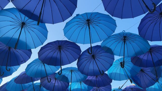 Blue umbrellas create a layered outdoor display, festive decoration, summer leisure, colorful design, holiday decoration.