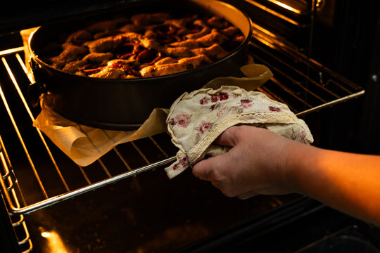 Famous New York Times plum torte baking in a round pan inside a hot oven with warm interior light