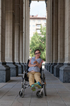 paralyzed female disabled person in a wheelchair on a walk around the city, accompanied by her husband's assistant