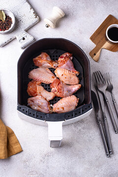 Raw uncooked chicken wings in air fryer