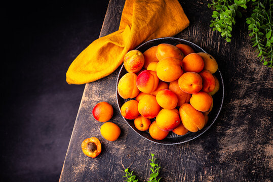 Fresh ripe apricots on dark background.