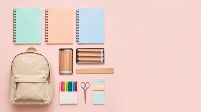 Pastel school supplies neatly arranged on a pink background, top view.