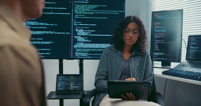Diverse team developer uses tablet discuss AI coding and project strategy at office. Artificial intelligence software debugging, Cybersecurity database server, Machine learning app meeting concept.