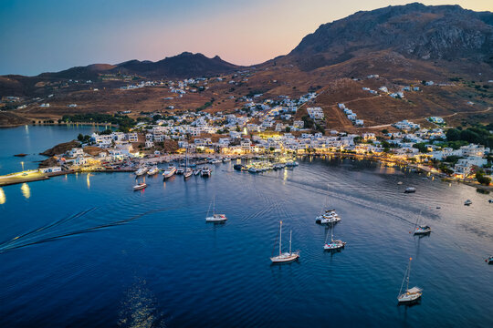 Aerial view of the illuminated town of Livadi, harbor and marina of Serifos island, during summer dusk, Cyclades, Greece