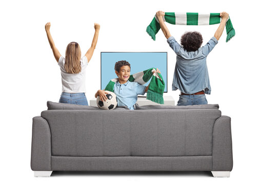 Mother, father and son cheering and watching a football match on television