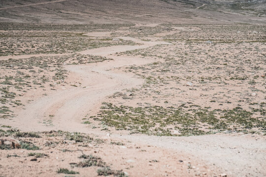 Dusty road of the Pamir Highway winds and twists in the valley of the Tien Shan mountains in Tajikistan in Pamir, landscape in the high desert mountains for background