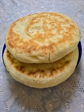 Freshly baked Moroccan batbout bread on a clean background.