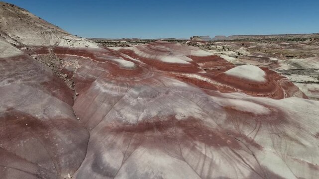 Slow motion sweeping aerial over striped Bentonite Hills in Utah